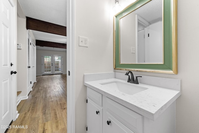 313 Sidney Martin Rd, Lafayette, LA 70507 - bathroom featuring french doors, wood finished floors, vanity, and beamed ceiling