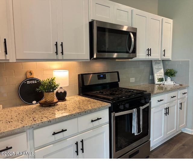 205 Acadian Lake Dr, Duson, LA 70529 - kitchen featuring stainless steel appliances, white cabinetry, decorative backsplash, and dark wood finished floors