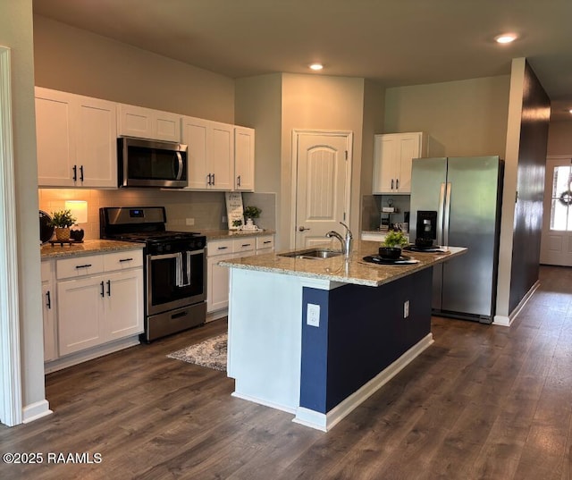 205 Acadian Lake Dr, Duson, LA 70529 - kitchen with stainless steel appliances, white cabinetry, dark wood-type flooring, backsplash, and an island with sink
