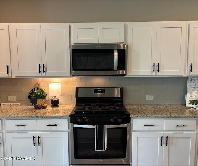 205 Acadian Lake Dr, Duson, LA 70529 - kitchen with appliances with stainless steel finishes, white cabinetry, and tasteful backsplash