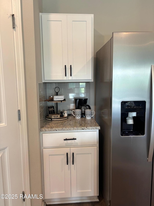205 Acadian Lake Dr, Duson, LA 70529 - kitchen featuring stainless steel refrigerator with ice dispenser, white cabinets, decorative backsplash, and light stone counters