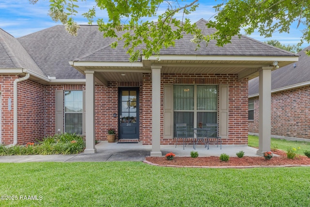 201 Spanish Moss Ln, Broussard, LA 70518 - property entrance with brick siding, a lawn, covered porch, and a shingled roof
