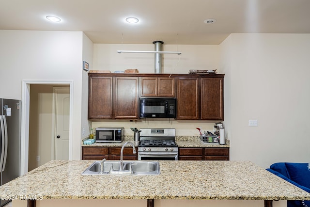 117 Gray Birch Loop, Youngsville, LA 70592 - kitchen with appliances with stainless steel finishes, an island with sink, dark brown cabinets, light stone counters, and recessed lighting