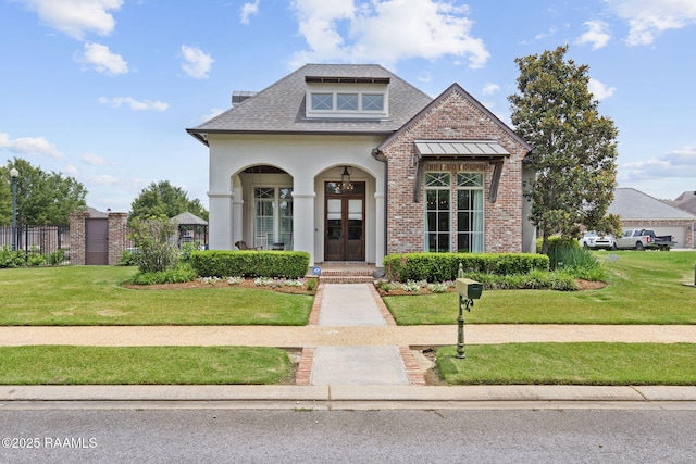 301 Gleneagles Cir, Broussard, LA 70518 - view of front facade with a front yard, brick siding, roof with shingles, french doors, and stucco siding