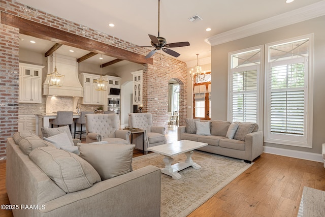 301 Gleneagles Cir, Broussard, LA 70518 - living area featuring a chandelier, arched walkways, a ceiling fan, light wood-style flooring, and beamed ceiling