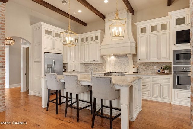 301 Gleneagles Cir, Broussard, LA 70518 - kitchen featuring appliances with stainless steel finishes, a chandelier, premium range hood, decorative backsplash, and beamed ceiling