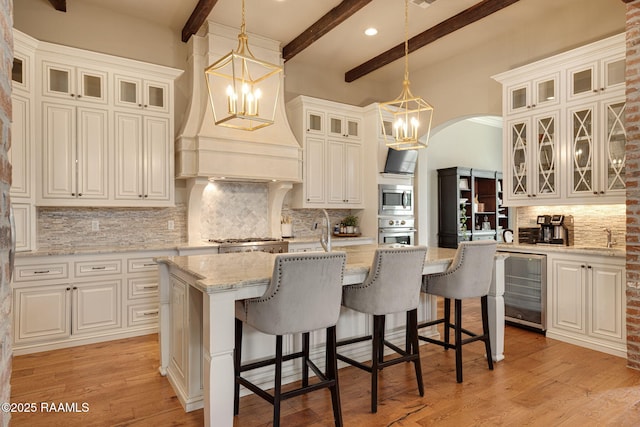 301 Gleneagles Cir, Broussard, LA 70518 - kitchen with stainless steel appliances, beverage cooler, beamed ceiling, tasteful backsplash, and a kitchen island with sink