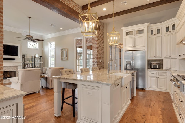 301 Gleneagles Cir, Broussard, LA 70518 - kitchen with stainless steel appliances, light wood-style flooring, a breakfast bar, open floor plan, and beamed ceiling