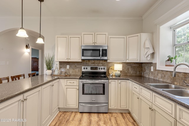 7804 Picard Rd, Maurice, LA 70555 - kitchen with appliances with stainless steel finishes, ornamental molding, hanging light fixtures, decorative backsplash, and arched walkways