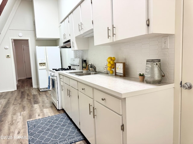 607 Ernest St, New Iberia, LA 70563 - kitchen with white appliances, under cabinet range hood, light wood-style flooring, light countertops, and decorative backsplash