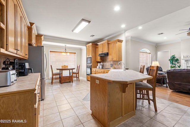 117 Montero Cir, Lafayette, LA 70503 - kitchen featuring tile counters, black appliances, ornamental molding, open floor plan, and light tile patterned floors
