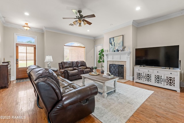 117 Montero Cir, Lafayette, LA 70503 - living room with ceiling fan, light wood-type flooring, a tiled fireplace, ornamental molding, and recessed lighting