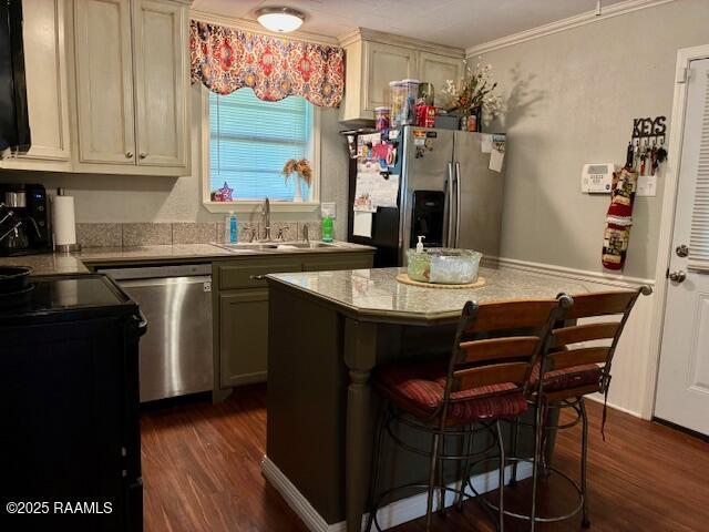 105 Sugar Dr, Broussard, LA 70518 - kitchen with stainless steel appliances, dark wood-style floors, a breakfast bar, a kitchen island, and ornamental molding
