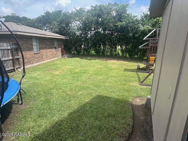 105 Sugar Dr, Broussard, LA 70518 - view of green lawn featuring a trampoline