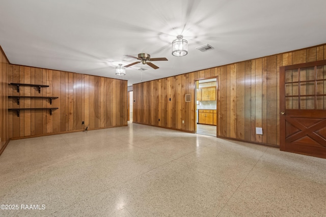 1212 S Main St, Breaux Bridge, LA 70517 - spare room featuring ceiling fan, wood walls, and dark aggregate flooring