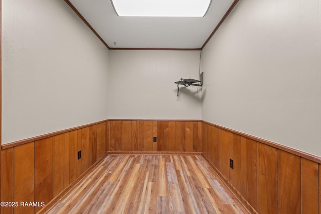 1212 S Main St, Breaux Bridge, LA 70517 - empty room featuring light wood-style flooring, wainscoting, crown molding, and wood walls