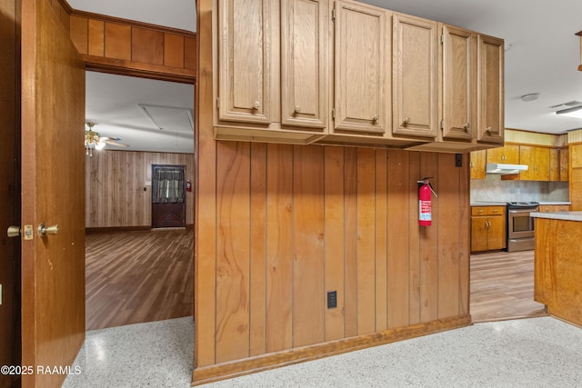 1212 S Main St, Breaux Bridge, LA 70517 - kitchen featuring electric range, backsplash, wood walls, under cabinet range hood, and a ceiling fan