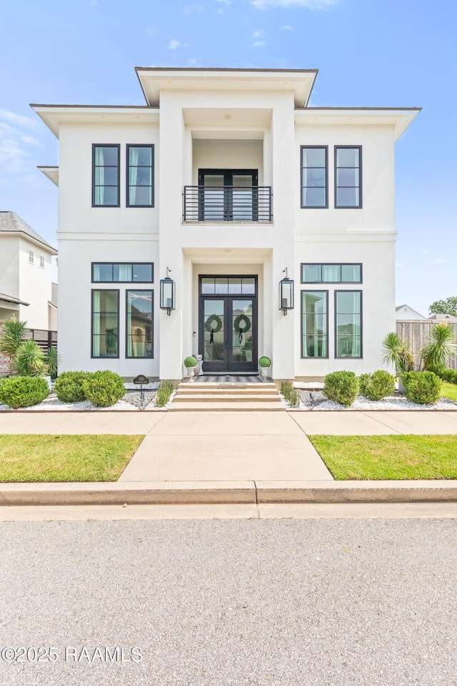 100 Catamaran Dr, Youngsville, LA 70592 - view of front facade featuring a balcony, stucco siding, and french doors