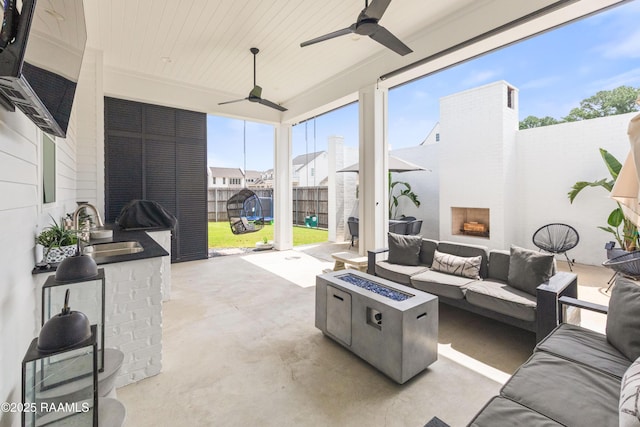 100 Catamaran Dr, Youngsville, LA 70592 - fenced backyard with a patio, an outdoor living space with a fireplace, and a ceiling fan