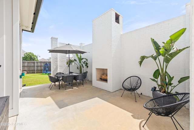 100 Catamaran Dr, Youngsville, LA 70592 - fenced backyard with a patio, an outdoor brick fireplace, and outdoor dining space