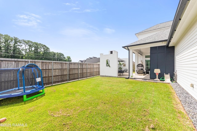 100 Catamaran Dr, Youngsville, LA 70592 - fenced backyard featuring a patio and a trampoline