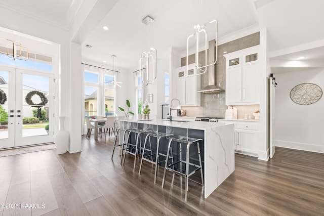 100 Catamaran Dr, Youngsville, LA 70592 - kitchen with dark wood-type flooring, a large island, wall chimney range hood, white cabinets, and recessed lighting