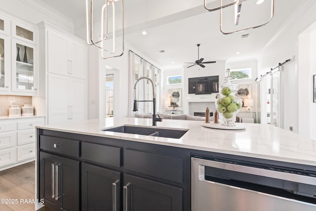 100 Catamaran Dr, Youngsville, LA 70592 - kitchen with stainless steel dishwasher, a barn door, white cabinets, open floor plan, and ornamental molding