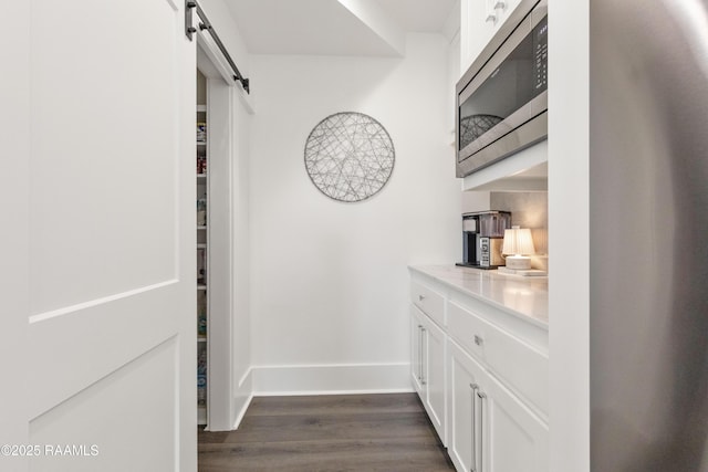 100 Catamaran Dr, Youngsville, LA 70592 - corridor with a barn door and dark wood-type flooring