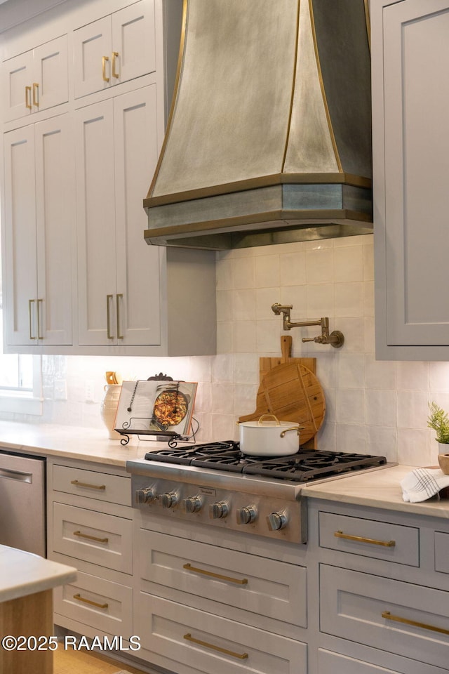 106 Sonoma Way, Lafayette, LA 70508 - kitchen featuring custom exhaust hood, stainless steel gas cooktop, backsplash, light countertops, and white cabinets