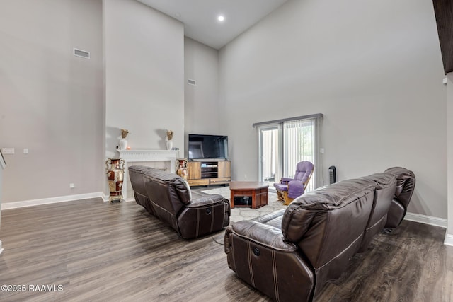 213 E Peck Blvd, Lafayette, LA 70508 - living area featuring wood finished floors, a towering ceiling, a tile fireplace, and recessed lighting
