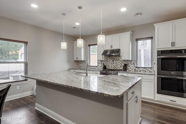 213 E Peck Blvd, Lafayette, LA 70508 - kitchen with appliances with stainless steel finishes, under cabinet range hood, backsplash, dark wood-type flooring, and recessed lighting
