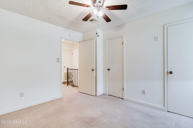 2421 Robley Dr, Lafayette, LA 70503 - unfurnished bedroom featuring light carpet, a textured ceiling, and a ceiling fan