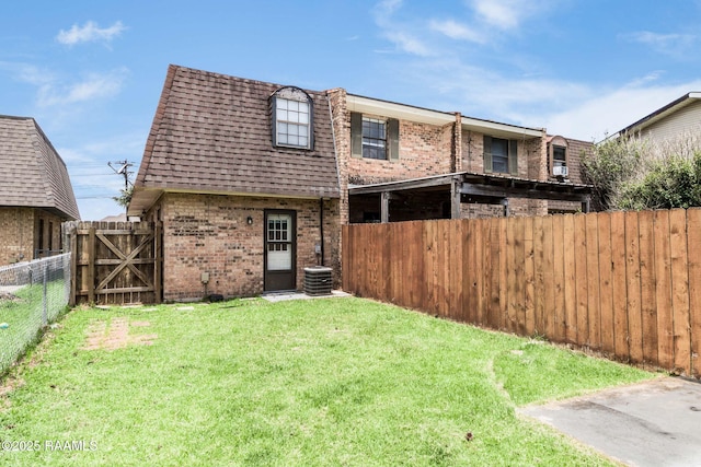 2421 Robley Dr, Lafayette, LA 70503 - back of property featuring brick siding, a fenced backyard, mansard roof, a shingled roof, and a gate
