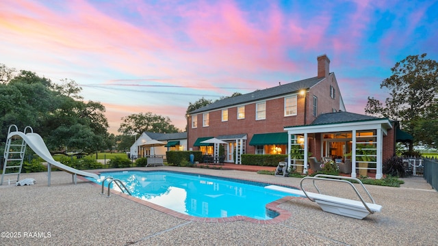6302 Old Jeanerette Rd, New Iberia, LA 70563 - pool at dusk featuring a water slide, a diving board, and a patio area