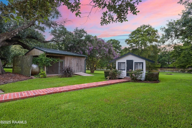 6302 Old Jeanerette Rd, New Iberia, LA 70563 - yard at dusk with an outdoor structure and a lawn