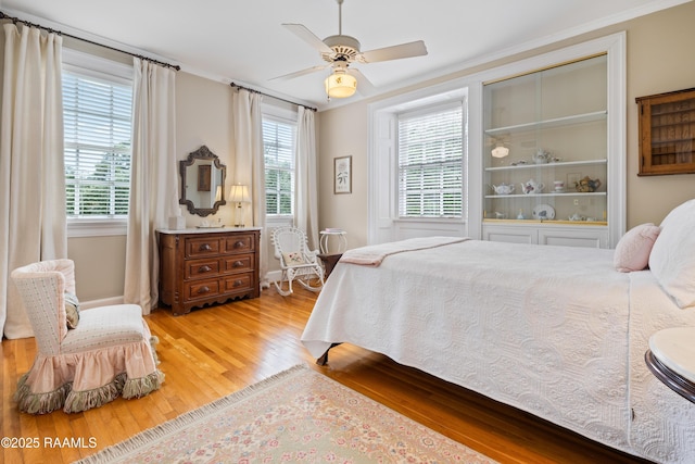 6302 Old Jeanerette Rd, New Iberia, LA 70563 - bedroom with multiple windows, light wood-type flooring, crown molding, and a ceiling fan