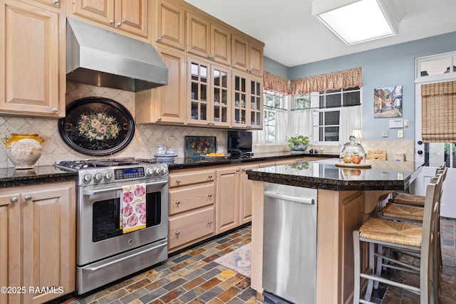 6302 Old Jeanerette Rd, New Iberia, LA 70563 - kitchen featuring gas range, under cabinet range hood, brick floors, backsplash, and a kitchen bar