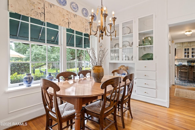 6302 Old Jeanerette Rd, New Iberia, LA 70563 - dining space featuring light wood-type flooring, a chandelier, and crown molding