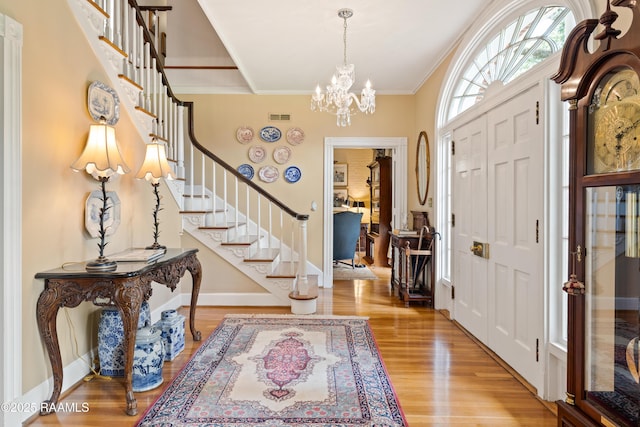 6302 Old Jeanerette Rd, New Iberia, LA 70563 - entrance foyer with stairs, wood finished floors, ornamental molding, and a chandelier