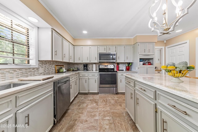 118 Garrigue Dr, Opelousas, LA 70570 - kitchen featuring stainless steel appliances, a chandelier, light stone countertops, backsplash, and pendant lighting