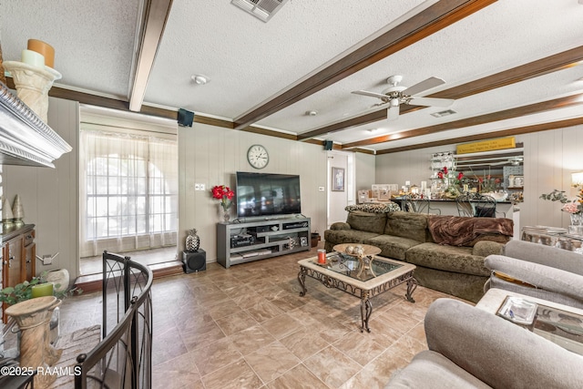 118 Garrigue Dr, Opelousas, LA 70570 - living room featuring a textured ceiling, beamed ceiling, ceiling fan, and a decorative wall