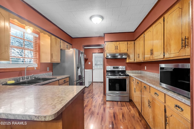 307 Bertrand Rd, Opelousas, LA 70570 - kitchen featuring appliances with stainless steel finishes, under cabinet range hood, light wood-style floors, washing machine and clothes dryer, and light countertops