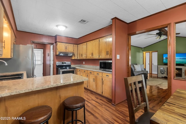 307 Bertrand Rd, Opelousas, LA 70570 - kitchen with appliances with stainless steel finishes, under cabinet range hood, light countertops, wood finished floors, and a peninsula