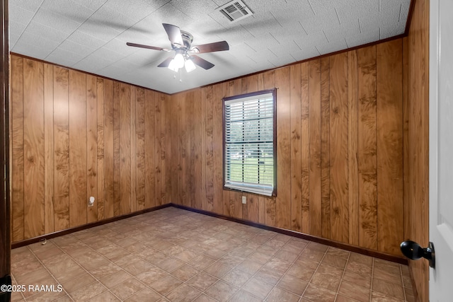 307 Bertrand Rd, Opelousas, LA 70570 - empty room with ceiling fan, tile patterned floors, and wood walls