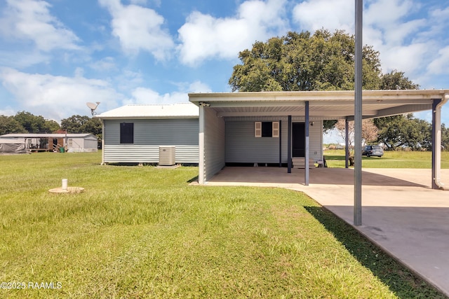 307 Bertrand Rd, Opelousas, LA 70570 - rear view of property featuring a yard, an attached carport, concrete driveway, and a metal roof
