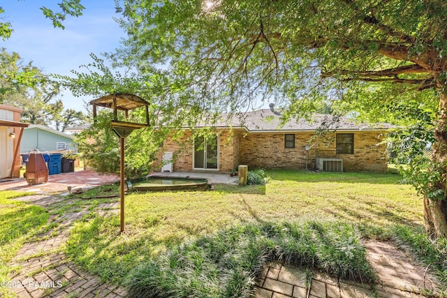 1912 Mimosa St, Abbeville, LA 70510 - back of house with a patio area, a lawn, and brick siding