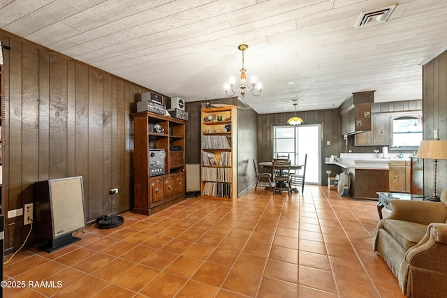 1912 Mimosa St, Abbeville, LA 70510 - living area with wooden walls, light tile patterned floors, a chandelier, and wood ceiling