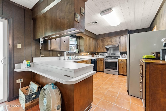 1912 Mimosa St, Abbeville, LA 70510 - kitchen featuring stainless steel gas stove, under cabinet range hood, black dishwasher, a peninsula, and light countertops