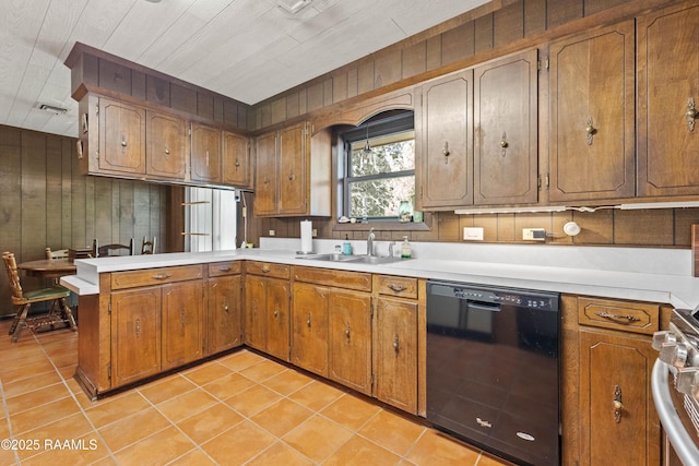1912 Mimosa St, Abbeville, LA 70510 - kitchen featuring dishwasher, a peninsula, brown cabinetry, light tile patterned flooring, and wooden walls