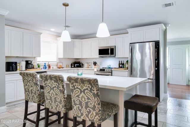 101 Barrow St, New Iberia, LA 70563 - kitchen with appliances with stainless steel finishes, crown molding, a breakfast bar area, light countertops, and tasteful backsplash